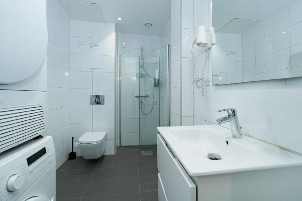 Penthouse Keluarga | Kamar mandi | Shower, pengering rambut, handuk, dan sabun