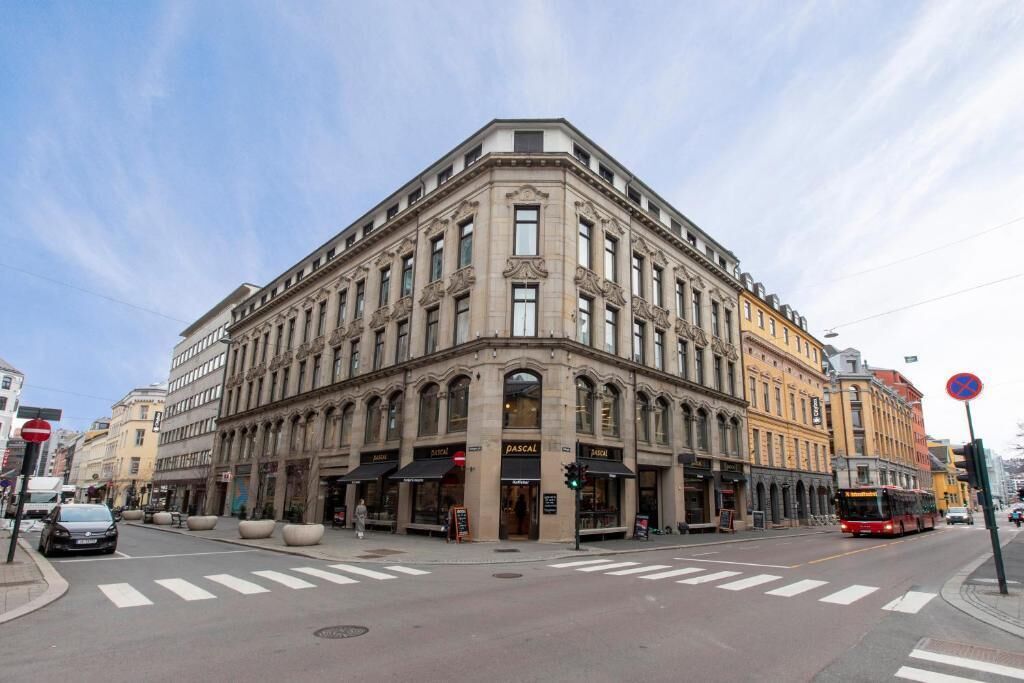 A corner building with multiple storefronts, including a visible 'PASCAL' sign.