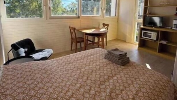 A bedroom with a bed, a desk, a chair, a TV, and a window. - La Résidence du Moulin 304 - Comfortable and quiet studio in Jonzac (Jonzac)