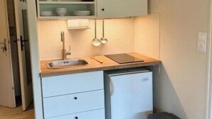 A compact kitchen with a sink, a small refrigerator, and a trash bin. - La Résidence du Moulin 304 - Comfortable and quiet studio in Jonzac (Jonzac)