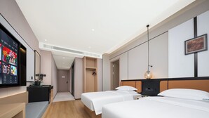 A hotel room with a TV, two beds, a wardrobe, and a hallway leading to another room. - Yiwu Aishang Mind Hotel (Jinhua)