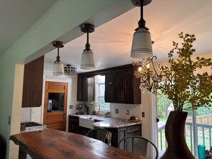 A kitchen with dark wooden cabinets, a marble countertop, and pendant lights. - Eclectic, custom home! Central to all KC (Shawnee)