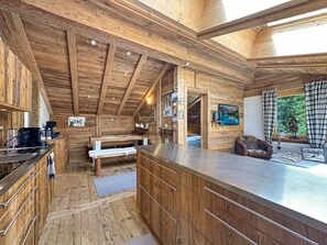 A wooden cabin interior with a kitchen, dining area, and a cozy seating space. - Matterhorn Alpine Hideaway - Cozy Renovated Apartm (Zermatt)