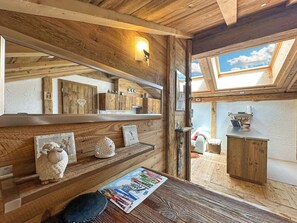 A rustic room with wooden beams, a skylight, and a wooden cabinet. - Matterhorn Alpine Hideaway - Cozy Renovated Apartm (Zermatt)