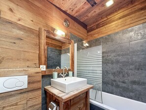 A bathroom with a wooden ceiling, a white sink, and a mirror. - Matterhorn Alpine Hideaway - Cozy Renovated Apartm (Zermatt)