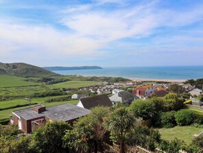 A coastal village with houses, a beach, and hills in the background. - Belvedere (Woolacombe)