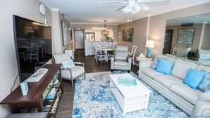A living room with a sofa, armchairs, a coffee table, and a dining area in the background. - Beach Time, Fun Time, All the Time B505 at the Dunes! Fantastic View (Panama City Beach)