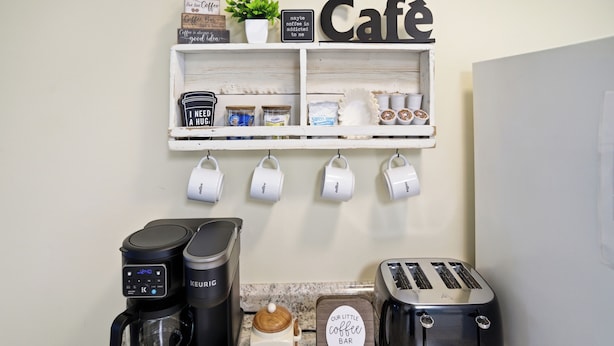 Ett köksutrymme med en kaffestation, inklusive en Keurig-kaffemaskin, en kaffekvarn och en brödrost.