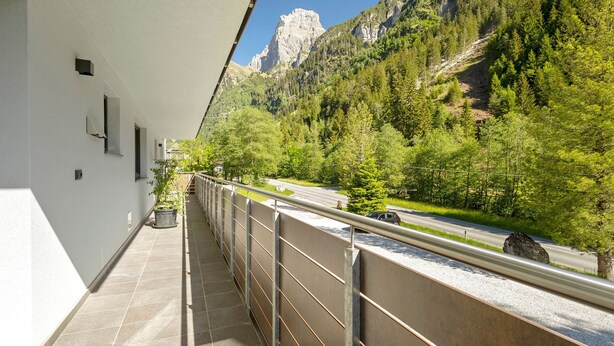 A balcony with a view of a mountain, a road, and a forest. - Family Apartment Nature House Bamboo – Lightness & Comfort with Mountain Views (Brennero)