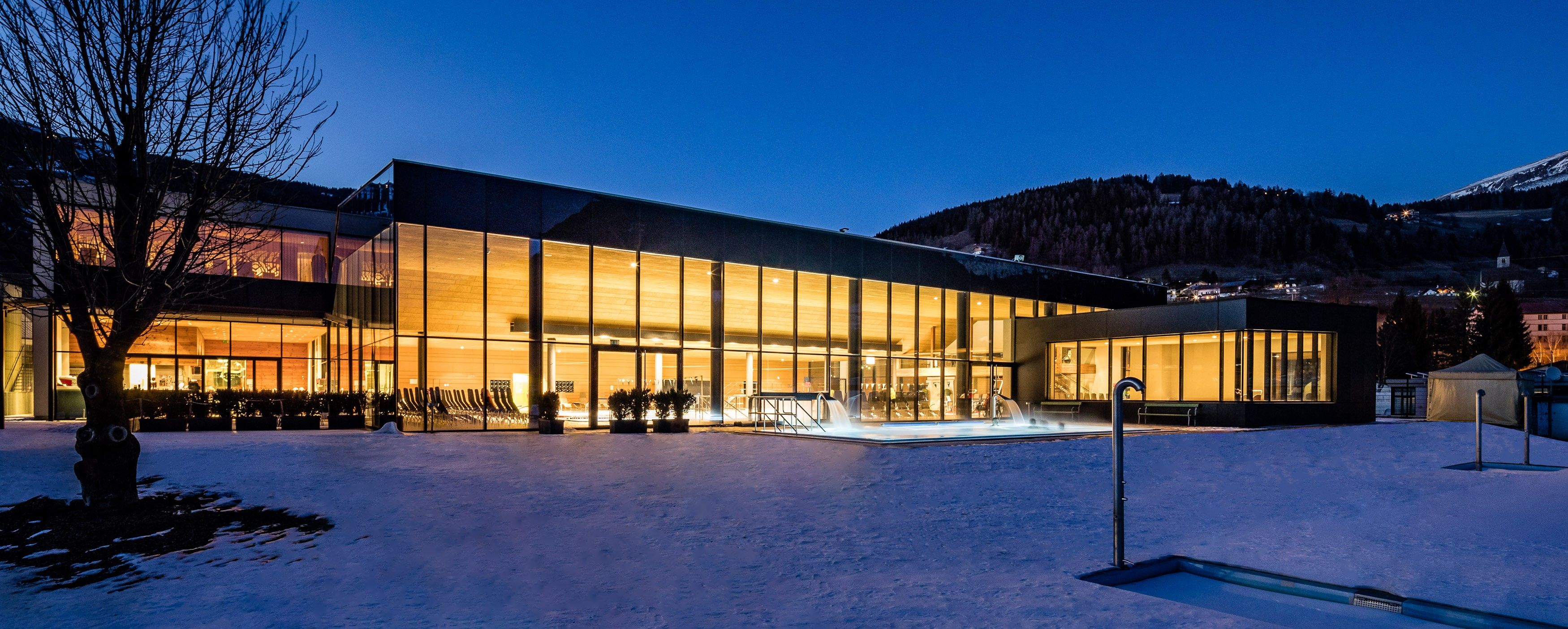 Een modern gebouw met grote glasramen en een met sneeuw bedekte grond.