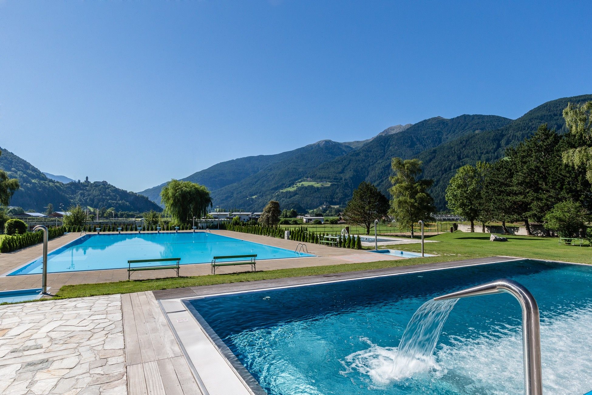 Una piscina con vistas a las montañas al fondo.