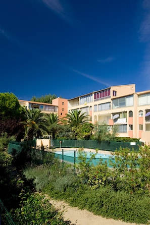 A multi-story hotel with balconies, a swimming pool, and lush greenery. - Family Stay Near Beach & Marina (Agde)