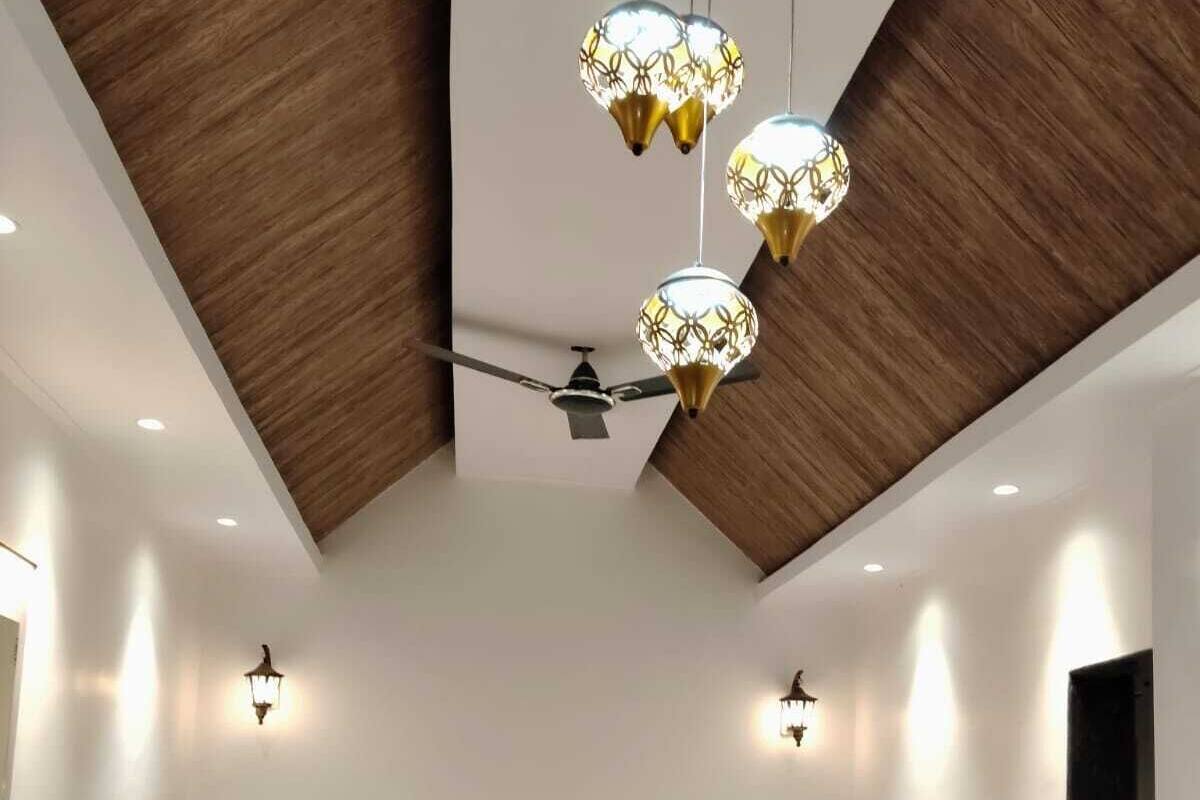 A modern bedroom with a large bed, a ceiling fan, and pendant lights.