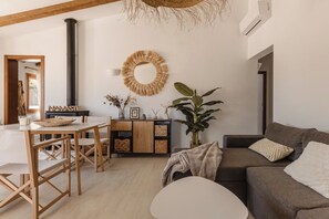Ein modernes Wohnzimmer mit Essbereich, Kamin, großem Spiegel und einer Topfpflanze.