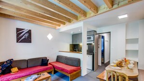 A compact living space with a sofa, a small table, a kitchenette, and a dining area. - Spacious 7-person Mountain Rental (Garin)