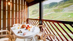 A wooden cabin with a table set for breakfast, overlooking a mountainous landscape. - Spacious 7-person Mountain Rental (Garin)