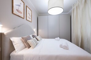 A neatly made bed with pillows, a headboard, and two framed pictures on the wall. - Angelico apt with terrace and lift (Firenze)