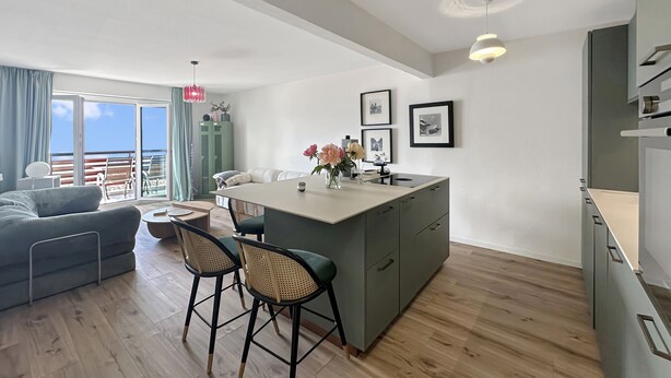 A modern apartment with a kitchen island, bar stools, a sofa, and a dining table. - Montana Alpine Outlook 4 Pax Panoramic Alps View (Crans-Montana)