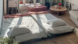 A bedroom with a bed, a round table, a chair, a potted plant, and a view through a glass door. - Montana Alpine Outlook 4 Pax Panoramic Alps View (Crans-Montana)