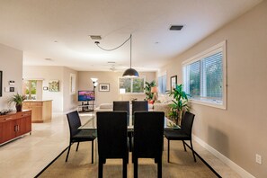 A dining area with a table, chairs, and a ceiling fan.