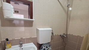 A bathroom with a sink, toilet, and shower. - Beautiful 1-bedroom apartment with AC in welcoming Budva (Budva)