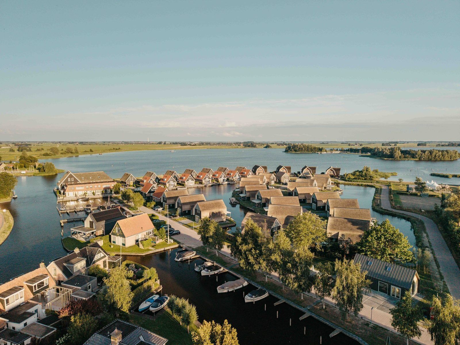 A riverside village with houses, a marina, and boats.