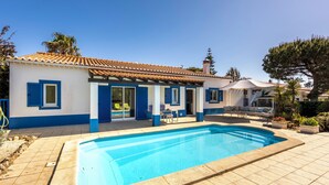 A house with a swimming pool, blue shutters, and a tiled roof. - Casa Jasmine - Fenced Garden, Pool and Algarve Sun (Vale da Telha)