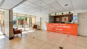 Uma área de recepção com balcão, um banco e vista para o exterior.