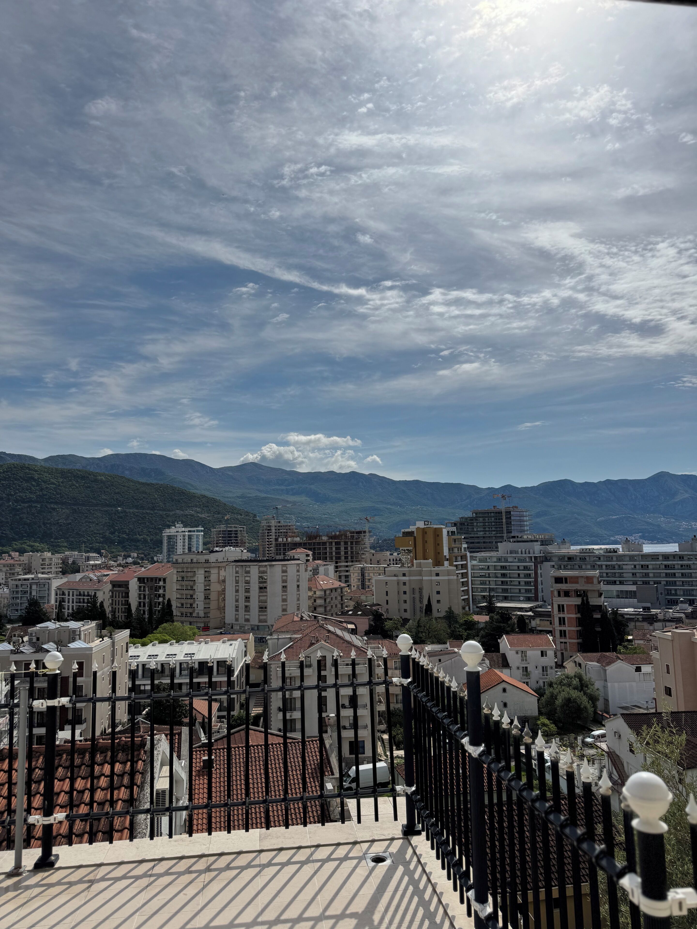 A cityscape with buildings, a clear sky, and mountains in the background.