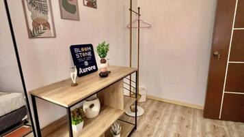 Une pièce comprenant une console en bois, un porte-manteau et des œuvres d’art murales.