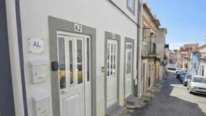 Una calle estrecha con edificios en fila, cada uno con una puerta numerada.