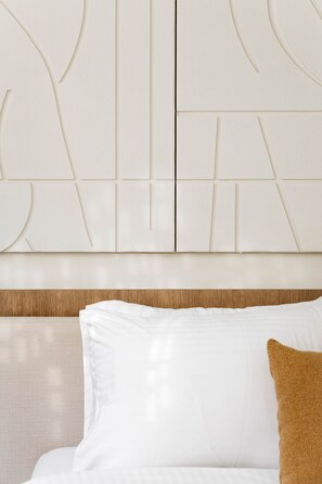 A bed with white bedding and a brown pillow, a wooden headboard, and a wall with geometric patterns. - Noemia Athens Near Acropolis Metro With Rooftop (Athens)