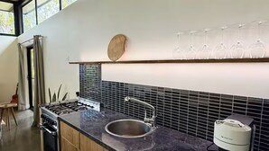 Une cuisine moderne équipée d’une cuisinière à gaz, d’un évier et d’un meuble à bouteilles.