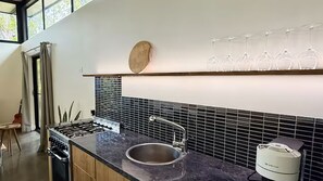 A modern kitchen with a gas stove, a sink, and a wine rack. - Teague Retreat Studio Space (South Kempsey)