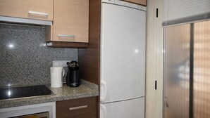Eine Küche mit Granit-Arbeitsplatten, einem weißen Kühlschrank und Holzschränken.