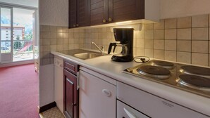 Una cocina con cafetera, fregadero y estufa.