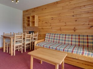 A wooden interior with a sofa, chairs, a table, and a wall-mounted shelf unit. - 1 BR Apartment for 6 in Les Deux Alpes (Les Deux Alpes)
