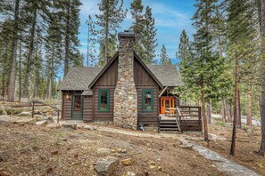 Eine Holzhütte mit Steinofen, Holzwänden und einer Veranda mit Bank.