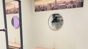 Ein Badezimmer mit Spiegel, Waschtisch und Stadtbild an der Wand.