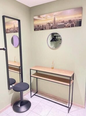 A bathroom with a mirror, a vanity, and a cityscape painting on the wall. - Fanta Flat France Switzerland - Comfort & Quiet near Basel (Saint-Louis)