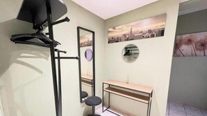 Ein kleines Badezimmer mit Spiegel, Waschbecken, Toilette und Handtuchhalter.