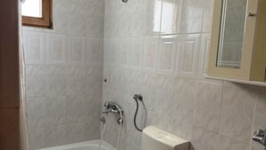 Een badkamer met een bad, toilet en wastafel.