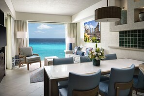A hotel room with a large balcony overlooking the ocean, a dining area, and a living space with a sofa and a TV. - WESTIN LAGUNAMAR - CANCUN-OCEAN VIEW- STUDIO VILLA - JANUARY 2-9 2027 (Cancún)
