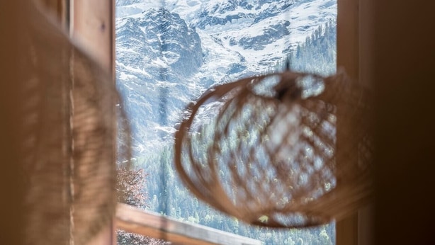 Una ventana con vistas a montañas nevadas.