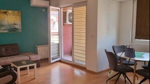 Una sala de estar con sofá, mesa de centro y un comedor con sillas y una mesa.