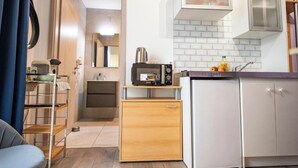 Uma cozinha compacta com micro-ondas, um pequeno frigorífico e uma pia.