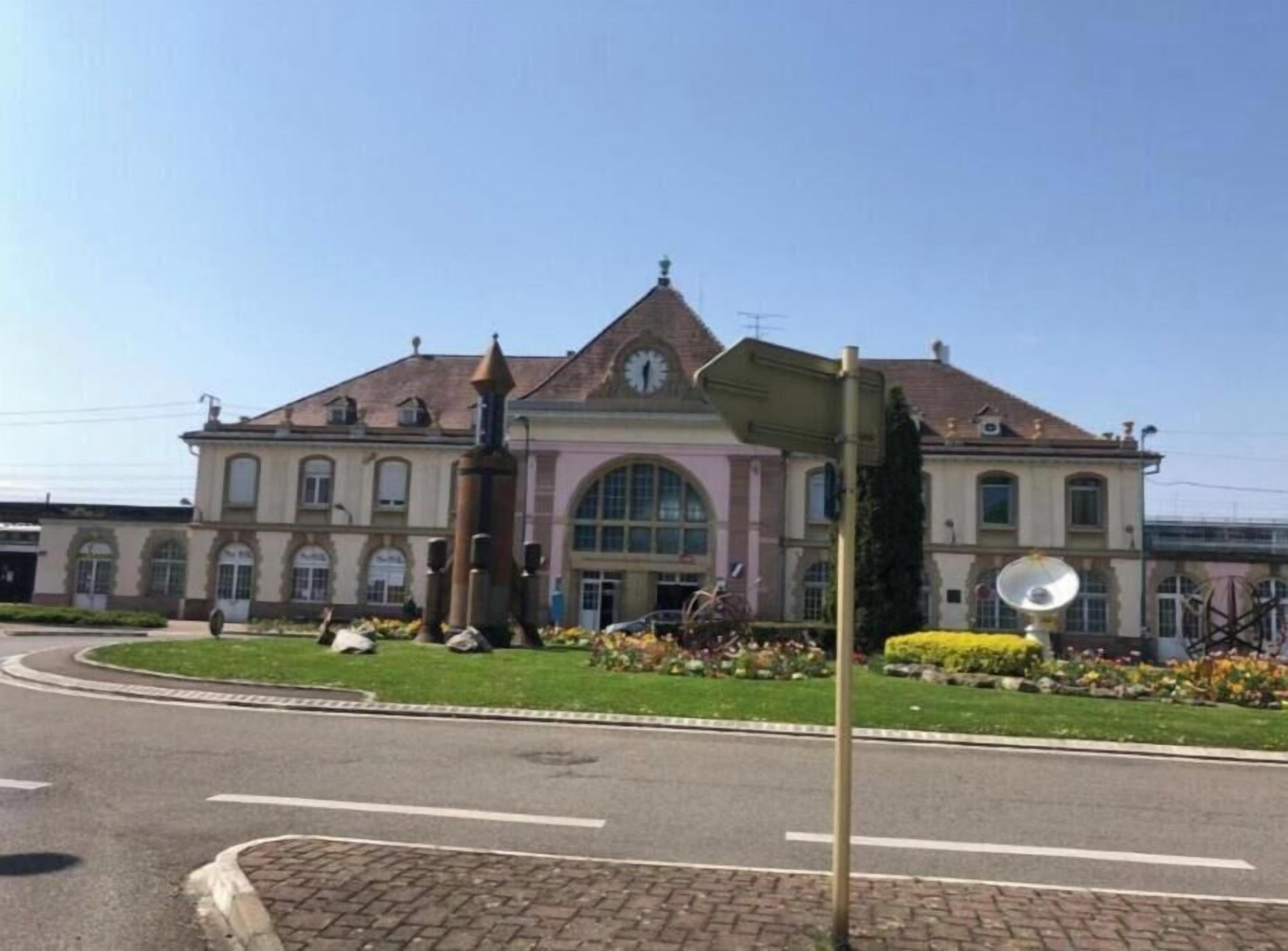 Um edifício grande com uma torre de relógio, um carrossel e um poste de luz.