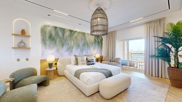 Un dormitorio de hotel moderno con una cama grande, vistas al balcón y un mural temático tropical.