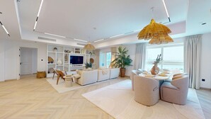 Un salón espacioso con un conjunto de sofás, una zona de comedor y un televisor.