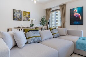 Ein modernes Wohnzimmer mit Sofa, Esstisch und Kunstwerken.